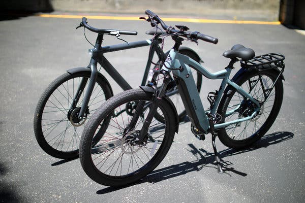 The Ride1Up e-bike, which is faster, in front of the VanMoof, which has a longer range on a full battery charge.