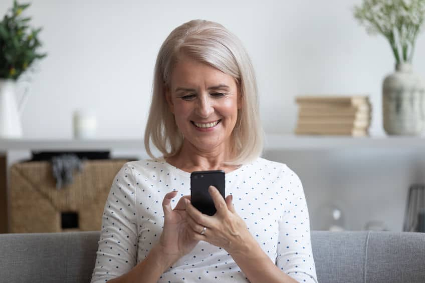 A woman plays an auditory training game on her phone.