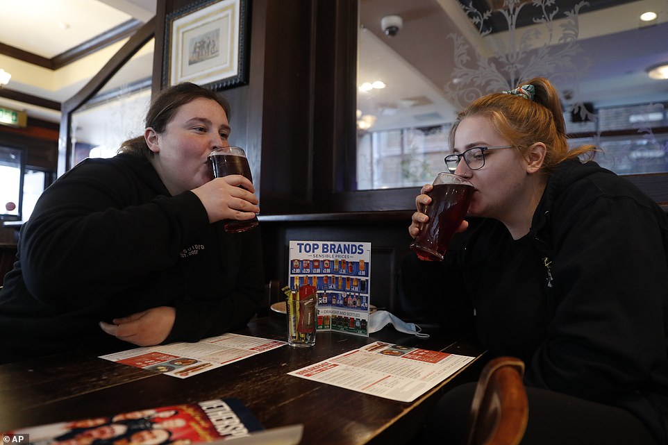 Libby Jones, right, with her colleague Shannon Maiden, both nurses from Great Ormond Street hospital who have just finished an overnight shift, have a pint of cider at the Shakespeare's Head pub