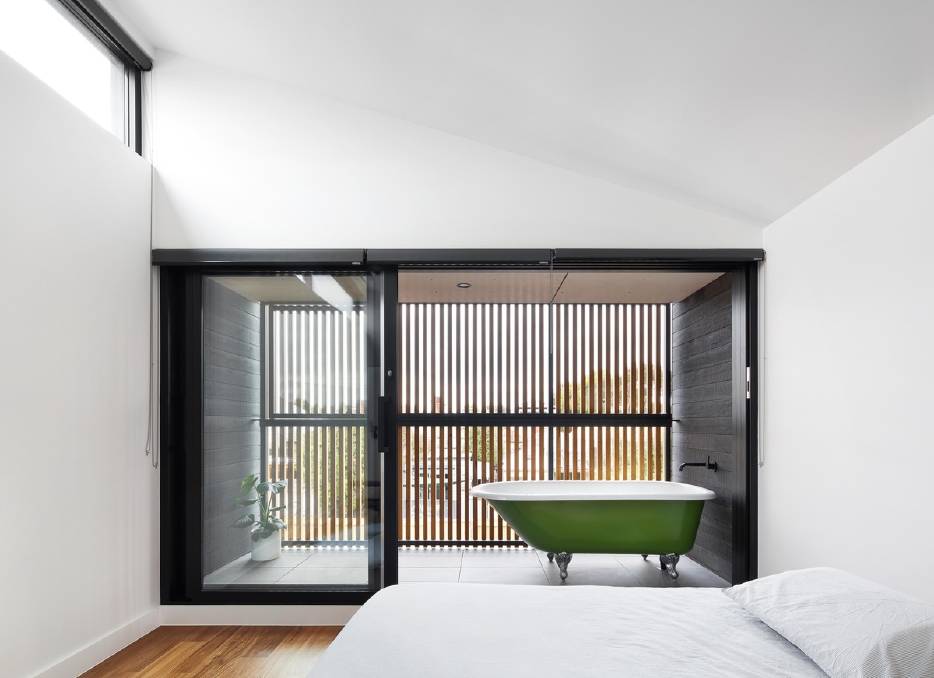 Hidden retreat: The upper timber battens shield a space devoted to indulgence with a clawfoot soaking tub nestled in a spa-like space off the master bedroom. 