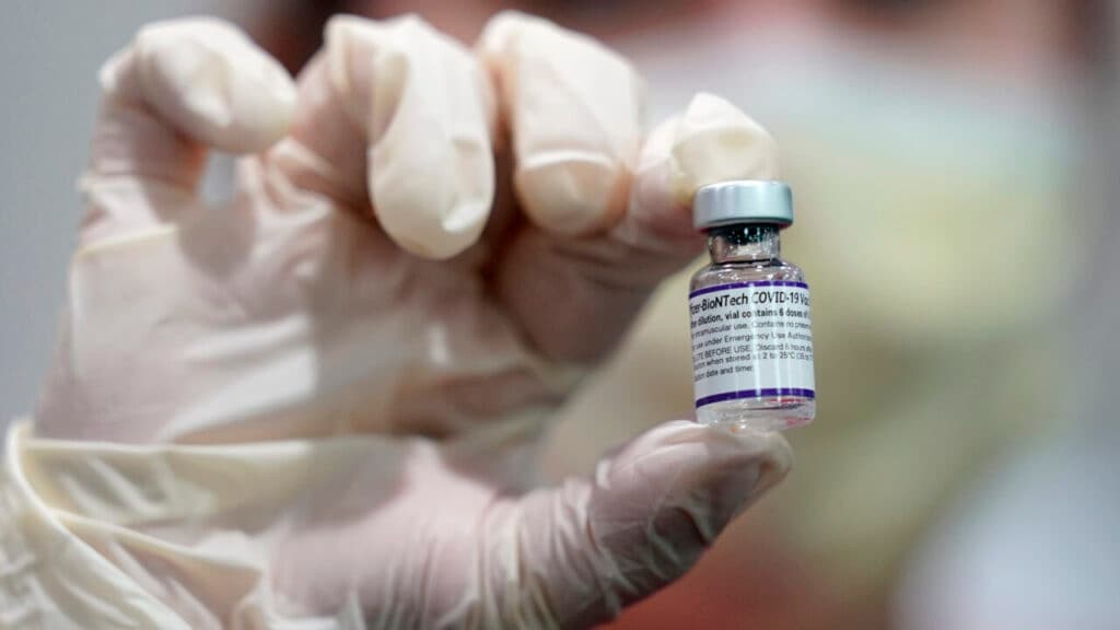 A healthcare worker holds a vial of the Pfizer COVID-19 vaccine